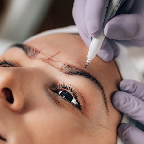 Microblading hair-stroke work on a client's brow